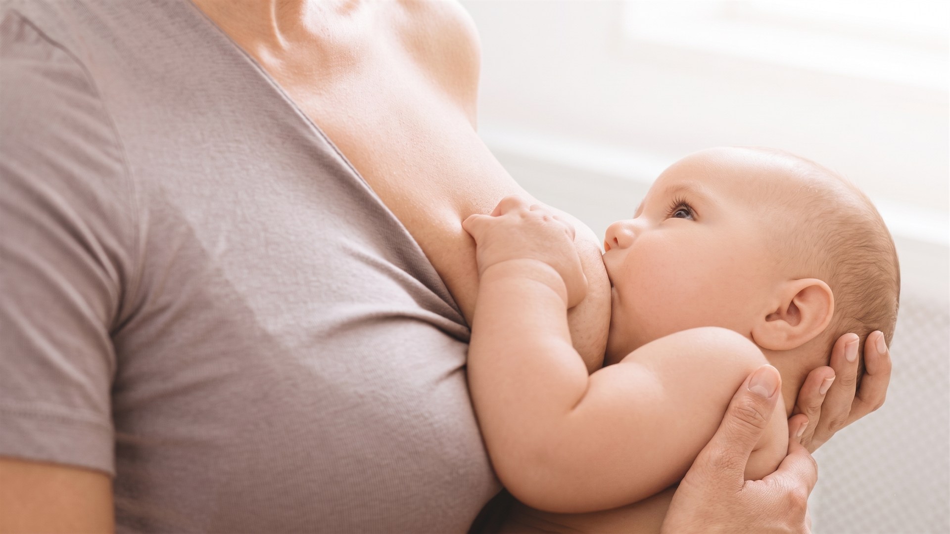 Mum breastfeeding her baby with quiet focus at the BMB Lactation Clinic